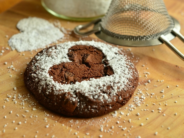 Ein Schokoladenkeks mit einem Herz aus Puderzucker