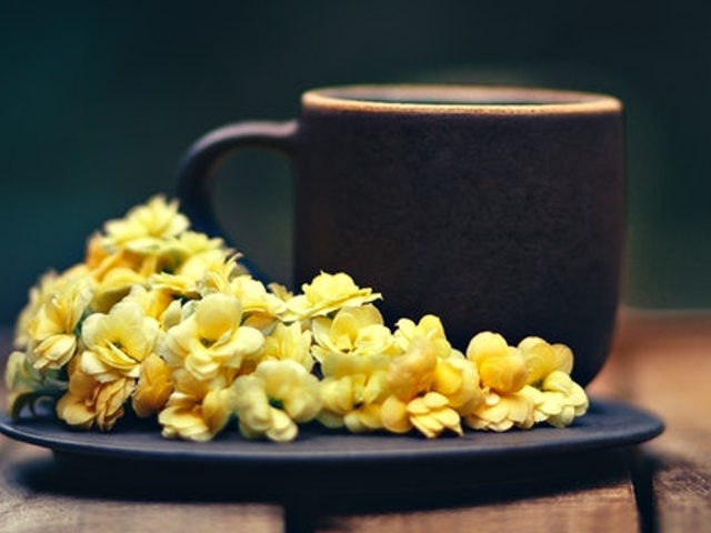 Eine Tasse Kaffee auf einem Unterteller mit gelben Blumen