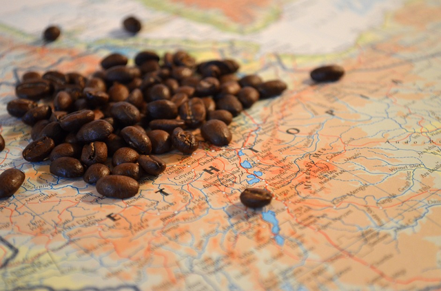 Kaffeebohnen liegen überhalb der Weltkarte verstreut. Unter ihnen steht Äthiopien.